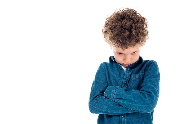 Criança encaracolado triste em camisa jeans de pé com braços cruzados isolados em branco — Fotografia de Stock