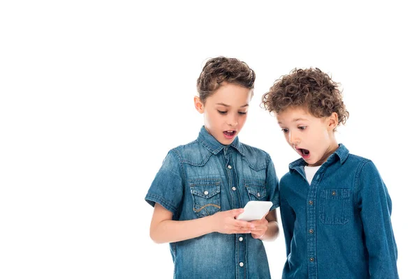 Дві шоковані діти використовують смартфон ізольовані на білому — стокове фото