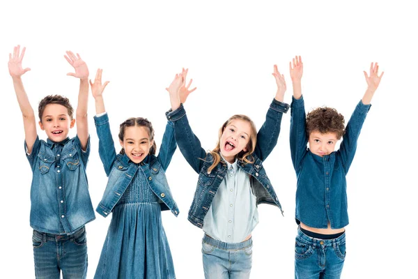 Front view of four kids in denim clothes smiling with hands up isolated on white — Stock Photo