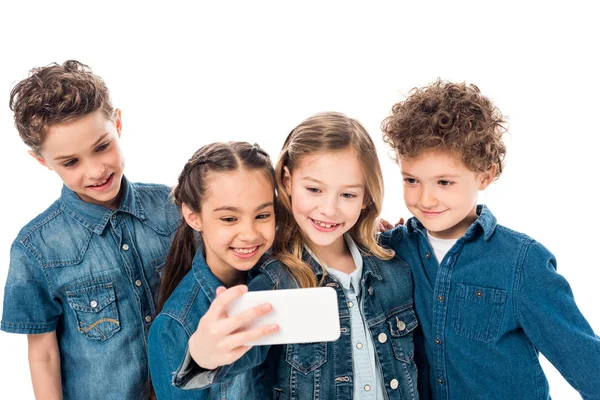 Quatre enfants souriants en denim prenant selfie isolé sur blanc — Photo de stock