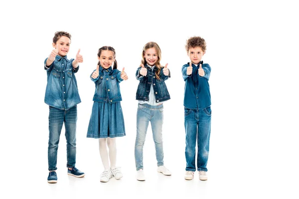 Vista completa de cuatro niños en ropa de mezclilla mostrando los pulgares hacia arriba aislados en blanco - foto de stock