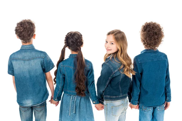 Niño sonriente cogido de la mano con amigos y mirando hacia atrás aislado en blanco - foto de stock