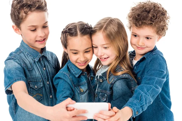 Vier lächelnde Kinder in Jeanskleidung machen ein Selfie isoliert auf Weiß — Stockfoto