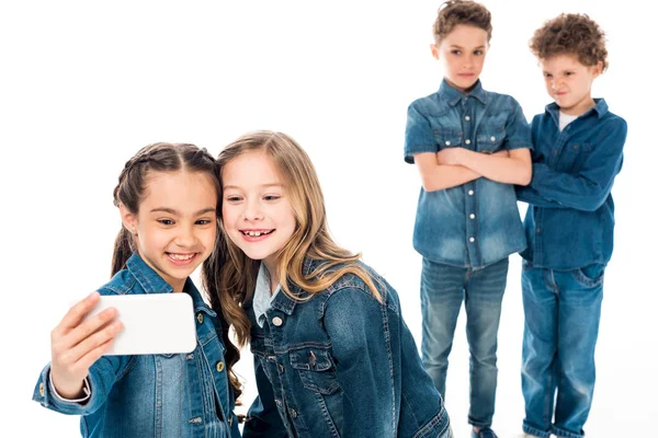 Niños en ropa de mezclilla tomando selfie aislado en blanco - foto de stock