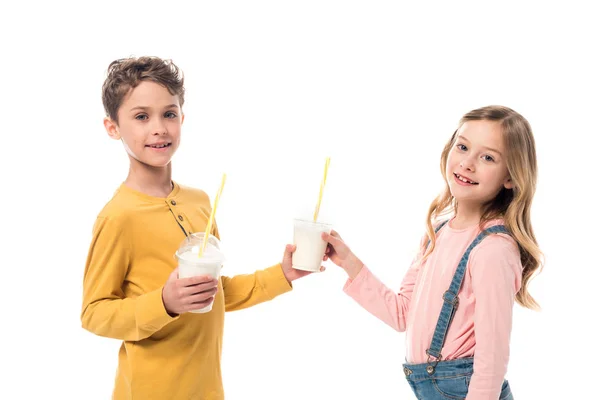 Deux enfants souriants tenant des milkshakes isolés sur blanc — Photo de stock