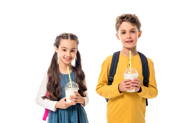Deux enfants heureux tenant milkshakes et regardant la caméra isolée sur blanc — Photo de stock