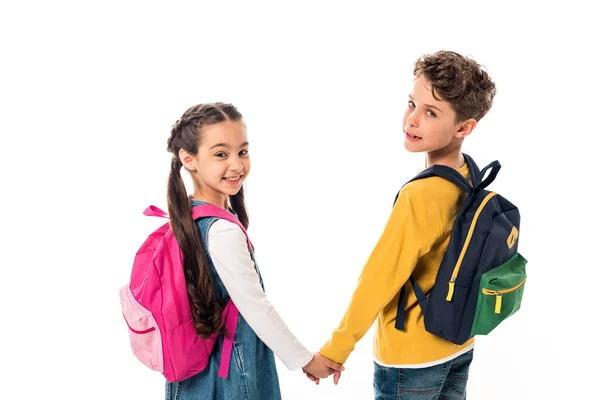 Escolares con mochilas cogidas de la mano y mirando hacia atrás aislados en blanco - foto de stock