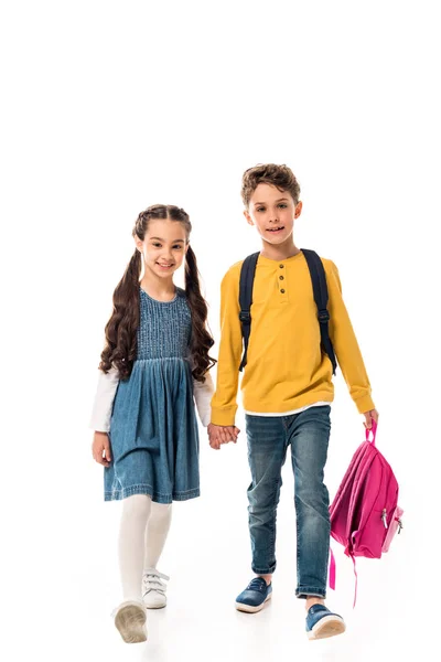 Full length view of schoolchildren with backpacks holding hands isolated on white — Stock Photo