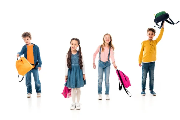 Vista completa de los escolares con mochilas en blanco - foto de stock