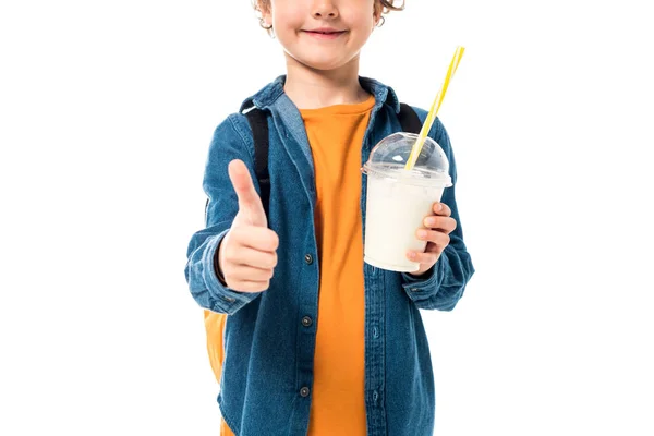 Vue partielle de l'écolier tenant le milkshake et montrant pouce vers le haut isolé sur blanc — Photo de stock