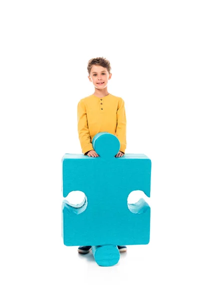 Full length view of smiling kid with big jigsaw puzzle on white — Stock Photo