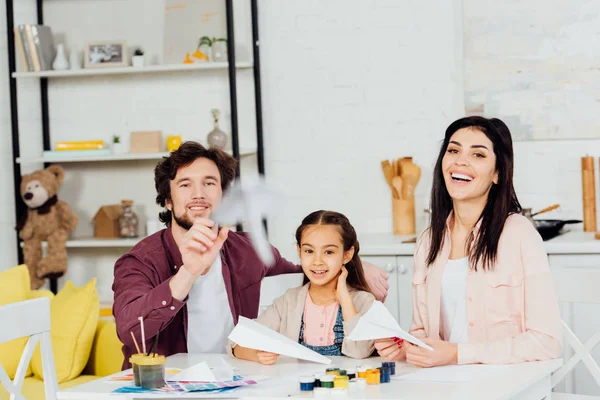 Selektiver Fokus glücklicher Familie auf fliegendes Papierflugzeug zu Hause — Stockfoto