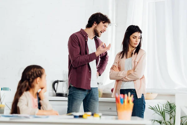 Selective focus of man quarreling with wife and gesturing near kid at home — Stock Photo