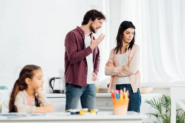 Messa a fuoco selettiva dell'uomo litigando con moglie vicino al bambino a casa — Foto stock