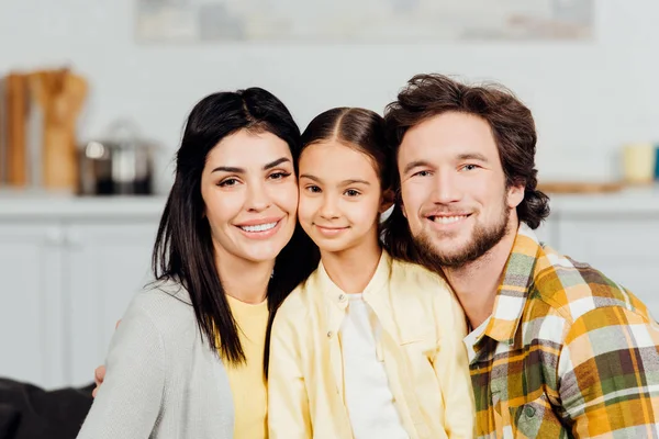 Positive Familie blickt in die Kamera und lächelt zu Hause — Stockfoto