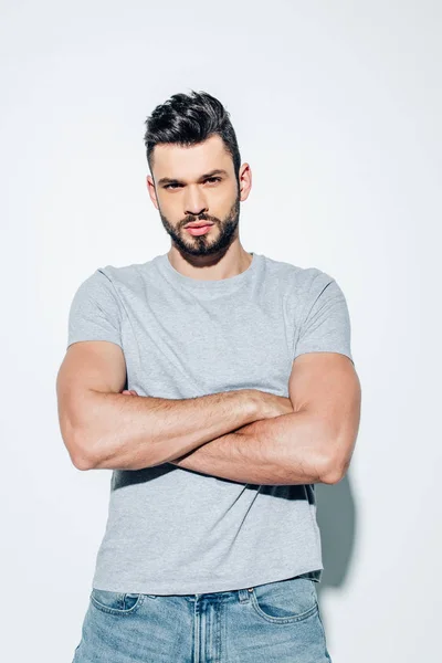 Handsome bearded man standing with crossed arms on white — Stock Photo