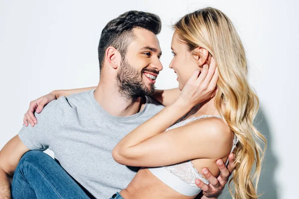 Happy bearded man looking at attractive blonde girl on white — Stock Photo