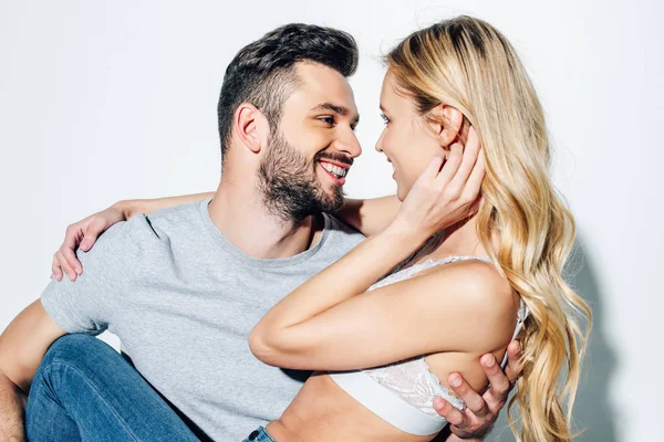 Homem barbudo feliz olhando para menina loira atraente no branco — Fotografia de Stock