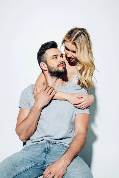 Attractive blonde girl looking at handsome man on white — Stock Photo