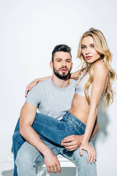 Atractiva mujer rubia mirando a la cámara con el hombre guapo en blanco — Stock Photo