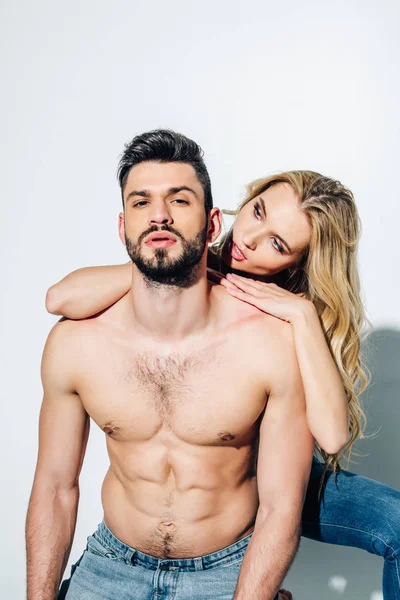 Shirtless bearded man looking at camera near attractive blonde woman on white — Stock Photo