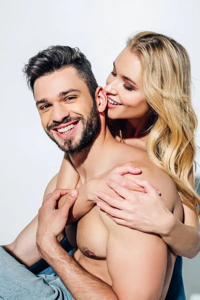 Happy woman hugging handsome boyfriend looking at camera on white — Stock Photo