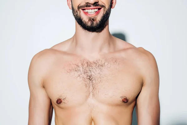 Vista recortada de hombre alegre y sin camisa sonriendo en blanco - foto de stock