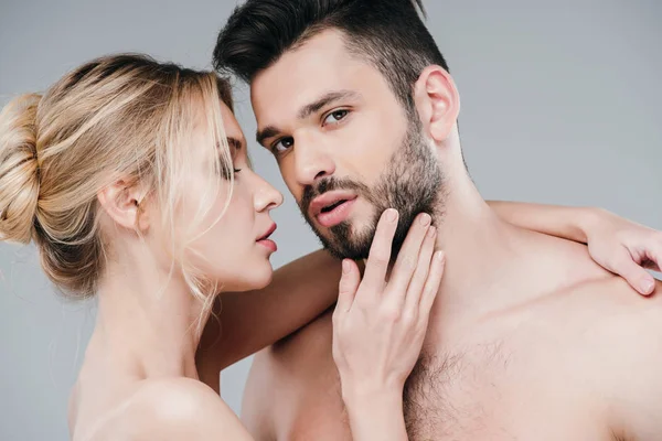 Attractive nude woman touching face of handsome bearded man on grey — Stock Photo