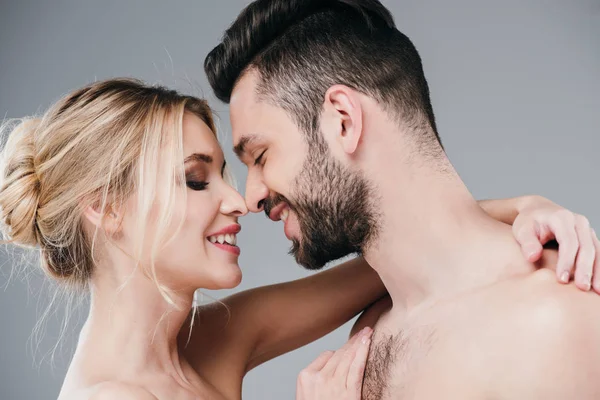 Schöne nackte junge Frau umarmt glücklich hemdlosen Mann auf grau — Stockfoto