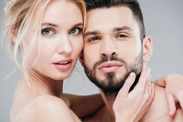 Close up of nude young woman touching face of handsome bearded man on grey — Stock Photo