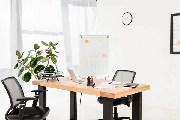 Escritório moderno com placa branca, planta e laptop na mesa — Fotografia de Stock