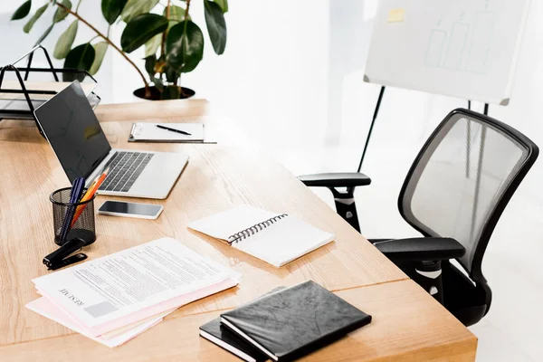 Modernes Büro mit Laptop, Smartphone, Lebenslauf und leerem Notizbuch auf dem Schreibtisch — Stockfoto