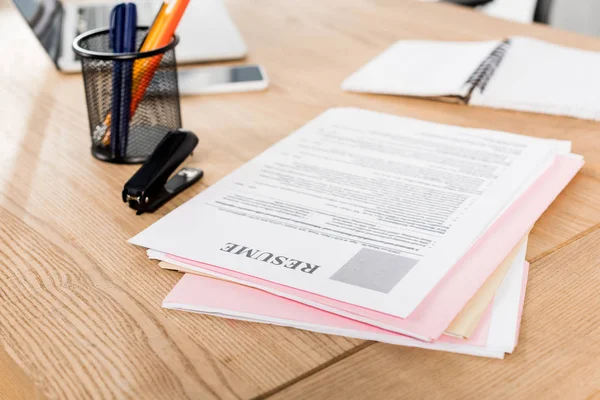 Enfoque selectivo de curriculum vitae cerca de grapadora y soporte de la pluma en la mesa — Stock Photo