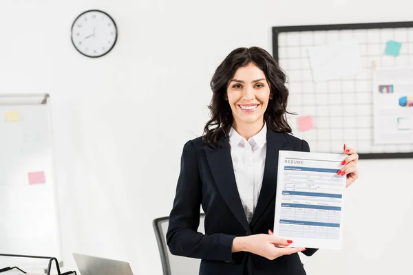 Attractive and cheerful recruiter holding resume in office — Stock Photo