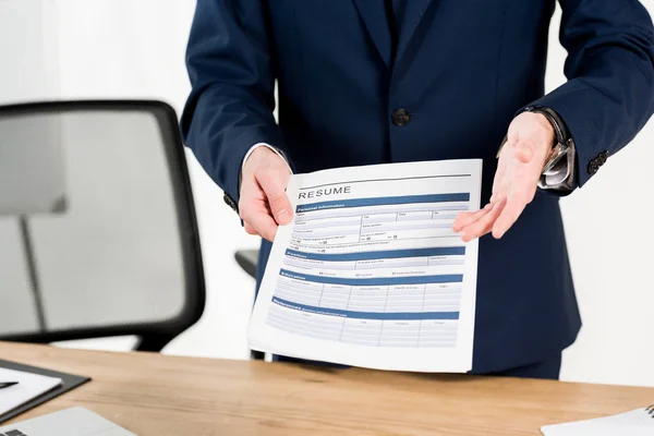 Cropped view of recruiter holding resume while gesturing in office — Stock Photo