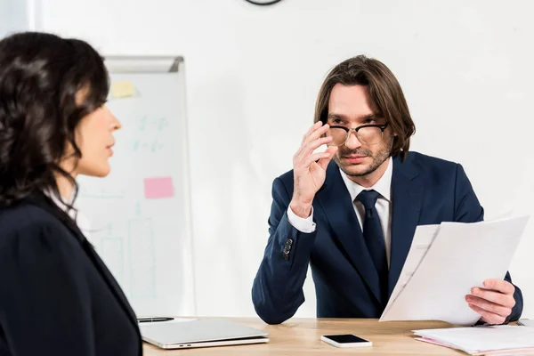 Selective focus of recruiter touching glasses while looking at attractive woman — Stock Photo