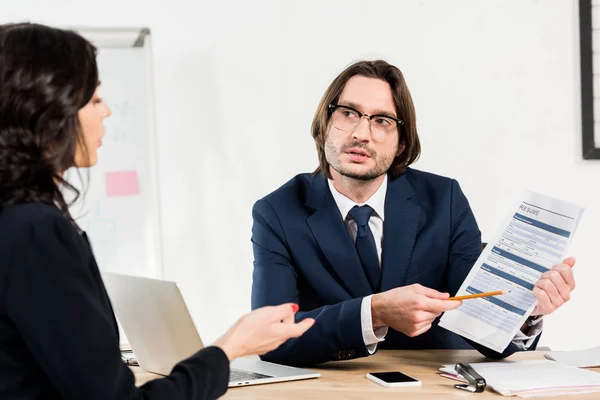 Selective focus of recruiter in glasses holding resume near woman — Stock Photo