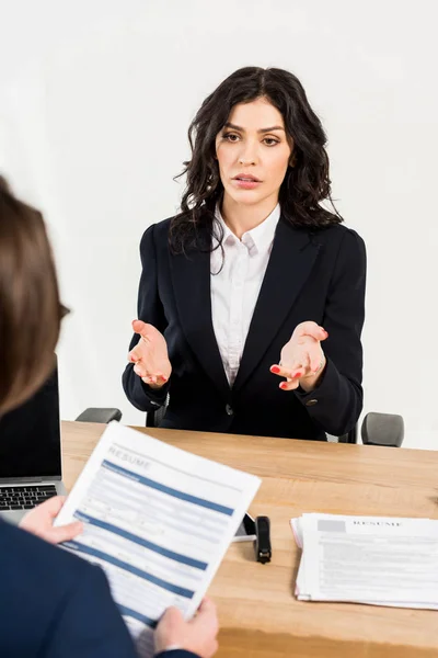 Enfoque selectivo de la mujer atractiva gesto mientras habla con el reclutador en la oficina - foto de stock