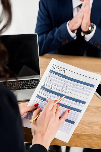 Selective focus of recruiter holding resume and pencil near man gesturing in office — Stock Photo