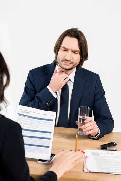 Selective focus of handsome man holding glass of water near recruiter in office — Stock Photo