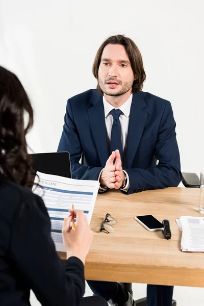 Enfoque selectivo de hombre guapo hablando mientras tiene entrevista de trabajo en la oficina - foto de stock