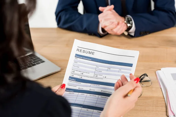 Cropped view of recruiter holding resume near employee with clenched hands — Stock Photo