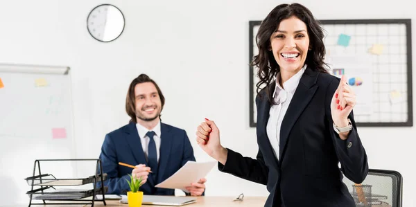 Panoramic shot of cheerful woman looking at camera near handsome recruiter — Stock Photo