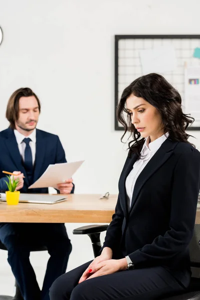 Selektiver Fokus einer aufgebrachten Frau, die in der Nähe eines gutaussehenden Personalvermittlers sitzt — Stockfoto