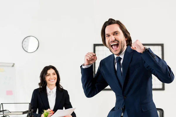 Selective focus of happy man gesturing near attractive recruiter in office — Stock Photo
