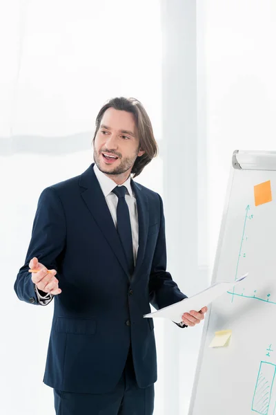 Schöner Mann spricht, während er Papier und Bleistift in den Händen hält — Stockfoto