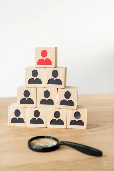 Selective focus of management hierarchy pyramid near magnifier on white — Stock Photo