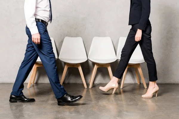 Cropped view of man and woman in formal wear walking in office — Stock Photo