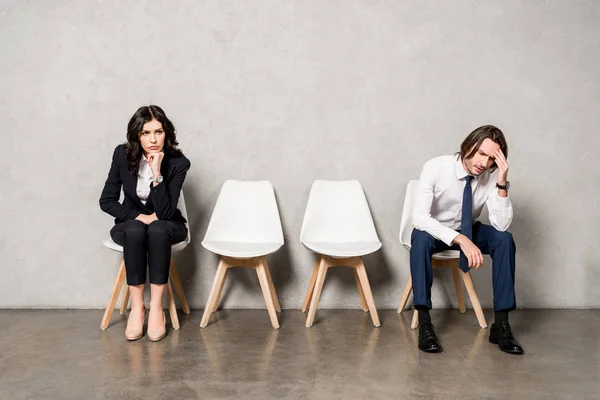 Worried man sitting near attractive brunette woman on chair — Stock Photo