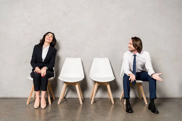 Happy man looking at attractive woman smiling while sitting on chair — Stock Photo